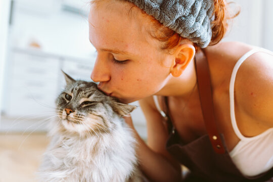 Portrait red-haired curly young woman with beloved fluffy domestic cat