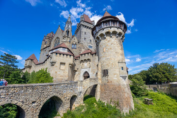 Castle landmark under blue sky. Medieval castle in Austria. Ancient historical sights around Vienna. Castle Kreuzenstein old building from outside