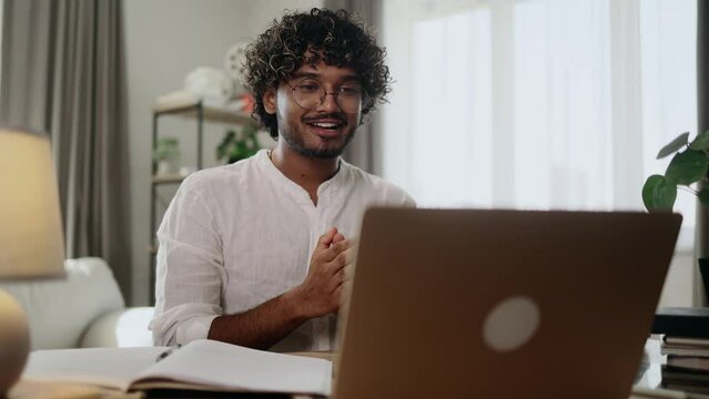 Portrait of handsome young indian man having video call conference meeting by laptop computer at home workplace Smiling confident male talking on working or personal conversation indoors
