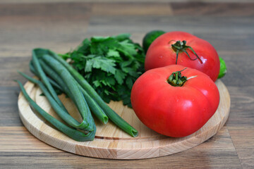 a cutting board with a bunch of green parsley and some other vegetables  