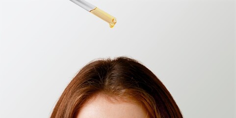 A young woman hand applies oil drop to hair