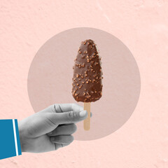 A hand holding a chocolate ice cream stick