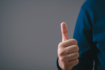 man hand showing thumbs up, closeup shot. Good or excellent and positive happy feeling. Success or approve a nice work emotion sign.