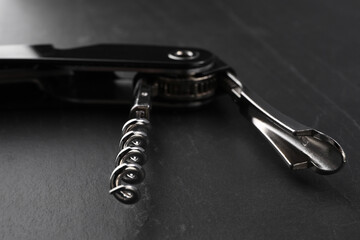 One corkscrew (sommelier knife) on grey textured table, closeup