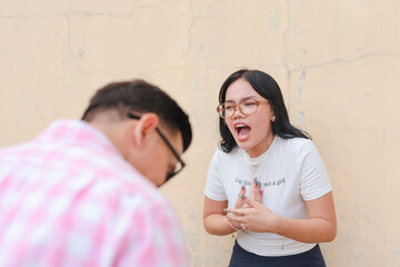 An angry young asian woman voices out her grievances to a ashamed dad. Outdoor urban scene.