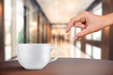 Woman hand and cup of coffee in room