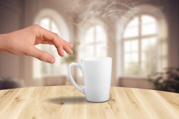 Woman hand and cup of coffee in room