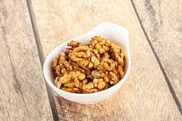 Cracked unshelled walnut in the bowl