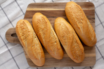 Homemade Mini baguettes on a wooden board, top view. Flat lay, overhead, from above.