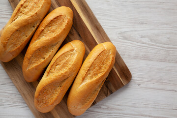 Homemade Mini baguettes on a wooden board, top view. Flat lay, overhead, from above. Copy space.