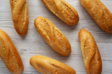 Homemade Mini baguettes on a wooden board, top view. Flat lay, overhead, from above.