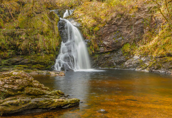Obraz premium Clear orange and brown coloured waters of an irish waterfall