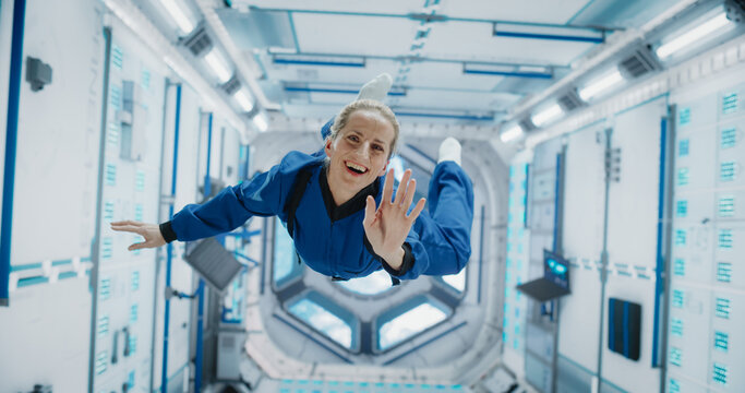 Portrait of a Courageous Female Astronaut on Board a Spacecraft, Floating in Zero Gravity and Smiling At The Camera. Space Travel, Solar System Exploration and Colonization Concept
