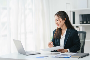 Businesswoman in a business suit is sitting at a desk with a laptop