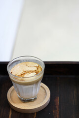 DIRTY coffee in clear glass on wooden table