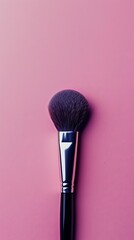 Professional makeup brush standing on a pink background for beauty concepts