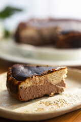 Homemade banana and chocolate Basque cheesecake with the cut piece on plate