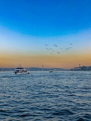 a boat is in the water with birds flying around it. Bosphorus Istanbul Turkey