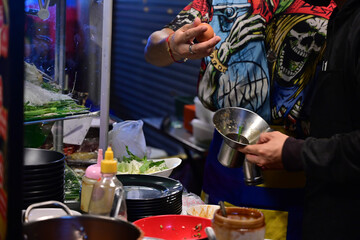 Street food cooking in a small stall along side the road in bangkok. Street food is one of The Most famous 