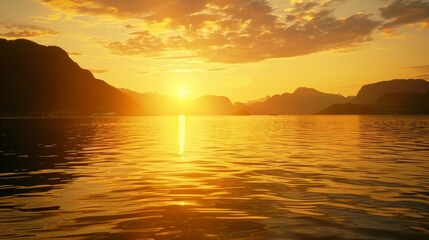 Obraz premium The sun sets over a pristine fjord the sky turning a warm golden hue as it reflects off the still waters below.