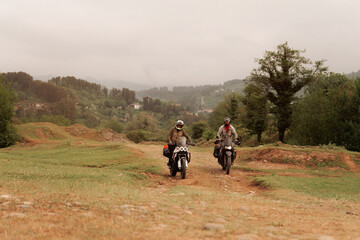 Obraz premium Bikers friends in motorcycle trip on adventure enduro motorcycles in mountains driving off-road