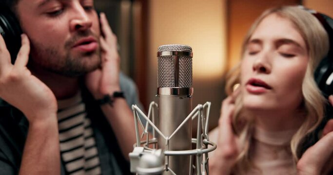 Group, musician and singing in music studio for song recording at booth with microphone for voice control. People, duo and artist or friends with headphone as singer for collaboration and teamwork