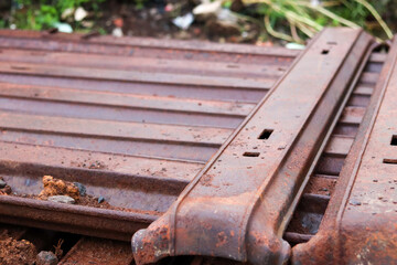 A pile of railroad sleepers made of iron, stacked together, showcases the heavy-duty materials used in railway construction, ensuring durability and stability for trains