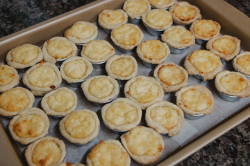 cheese quiches lined up on the baking sheet