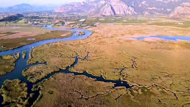 Aerial footage of Dalyan Delta wetland sunny weather in summer wide view of the delta and town camera tilting up slowly and moves forward Mugla TURKEY