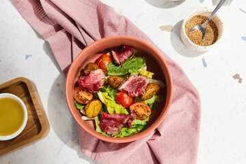 Fresh Roast Beef and Baked Potato Salad in a Pink Ceramic Bowl on a White Marble Countertop