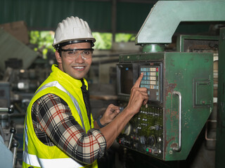 Confident factory workers are customizing machines in preparation for the production of industrial...