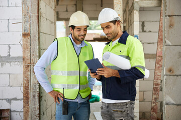 workers or architects meeting and working on tablet at construction site