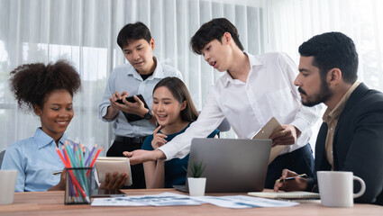 Multiracial analyst team use BI dashboard data to analyze financial report on meeting table. Group of diverse business people utilize data analysis by FIntech for success business marketing. Concord