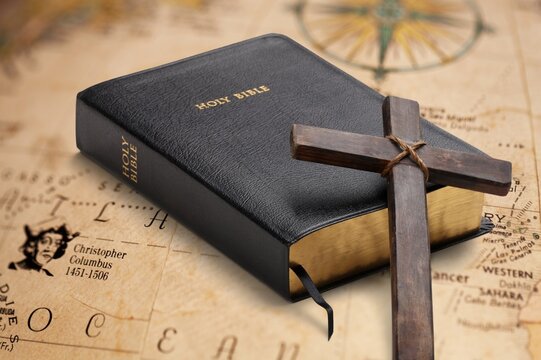 Holly bible book and cross on the map