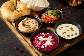 Mediterranean Meze Platter with Pita Bread: Hummus, Beetroot Hummus, Ajapsandali, and Tonnato Sauce
