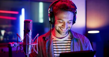 Man, musician and headphones with tablet in recording studio for music production, audio streaming and face in neon. Artist, happy and media industry with digital app for song lyrics and learning