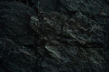 Black stone background. Dark rock surface texture at coast near the sea. Abstract pattern. Natural backdrop. Natural rock surface. Element, material design.