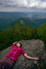 Naklejka premium Woman in pink shirt on the rock in Carpathian mountains