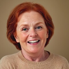 Old woman with red hair and blue eyes, smiling warmly at the camera. She has a natural look with visible wrinkles, wearing a beige sweater against a simple background. The overall mood is cheerful and