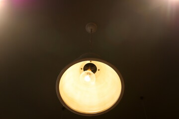 A lamp for illuminating the interior of the room hangs on the ceiling.