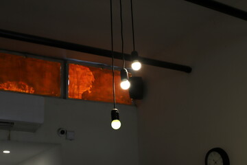 A lamp for illuminating the interior of the room hangs on the ceiling.