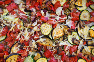 Oven-baked vegetables with eggplant, zucchini, bell pepper, onions and cheese, full frame background, high angle view from above, copy space