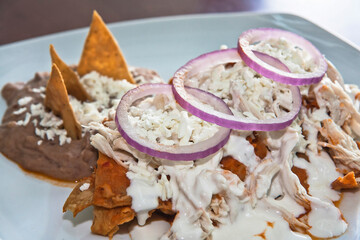 Mexican chilaquiles with chicken and spicy sauce traditional breakfast in Mexico, Mexican food