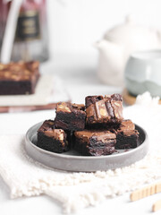Chocolate brownies squares with chocolate chips and walnuts slices on top. Freshly baked brownies. Best fudgy brownies cakes. Selective focus with shiny and rough texture