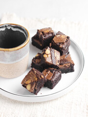 Chocolate brownies squares with chocolate chips and walnuts slices on top. Freshly baked brownies. Best fudgy brownies cakes. Selective focus with shiny and rough texture