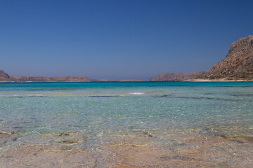A vast expanse of water set against a majestic backdrop of mountains, embodying a serene and...