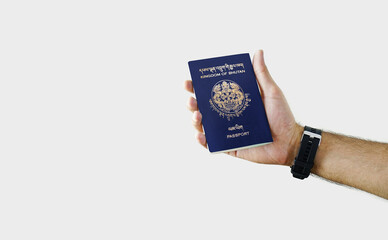 Fototapeta premium Man holding Bhutan Passport in hand on white background with copy space - Bhutanese