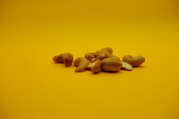 collection of cashew nuts isolated on dark yellow background