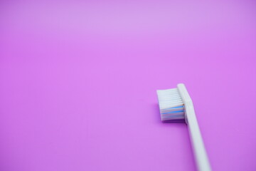 White toothbrush isolated on purple background