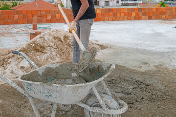 Labourer preparing mortar for construction.